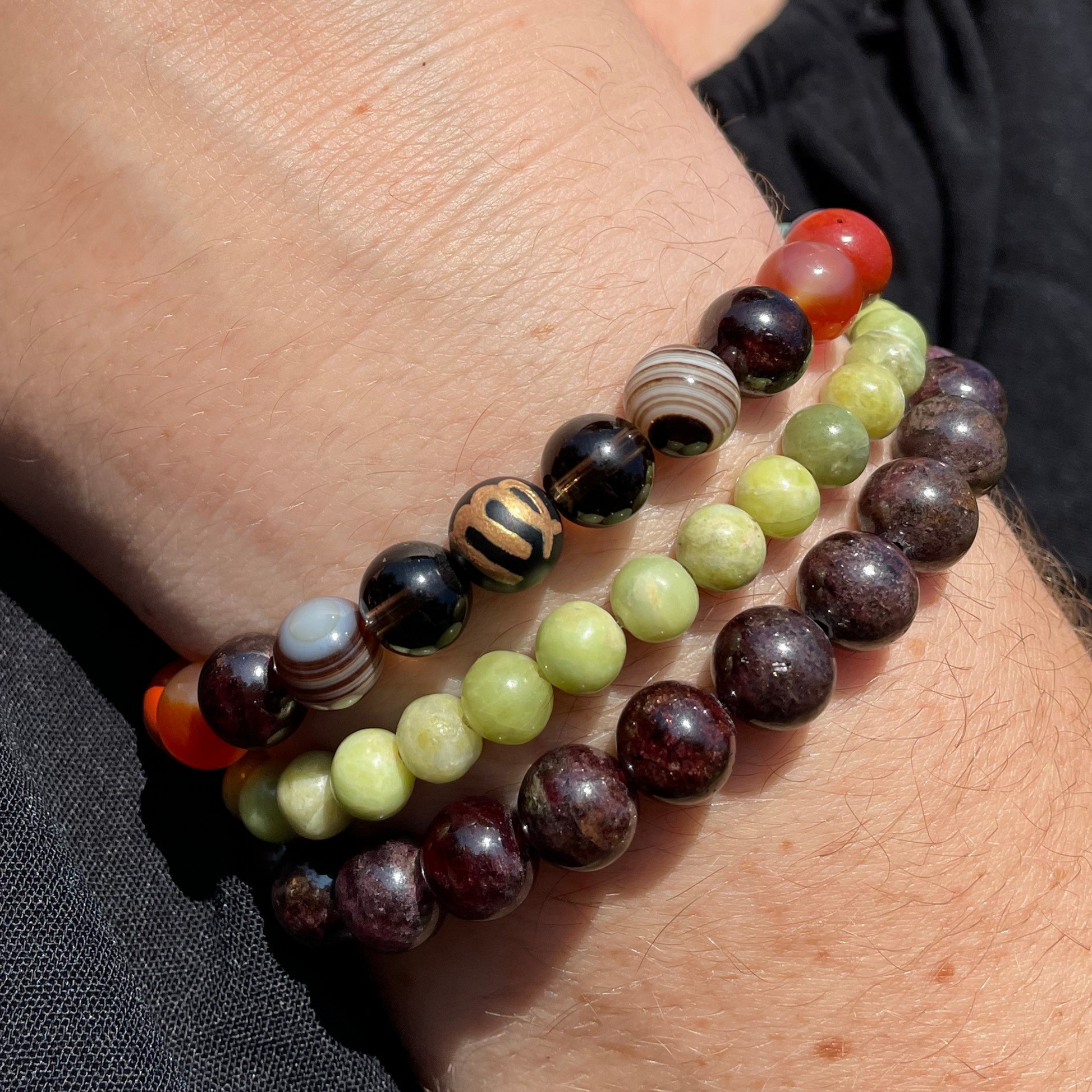 Multicolored beaded bracelets on a wrist with a neutral background