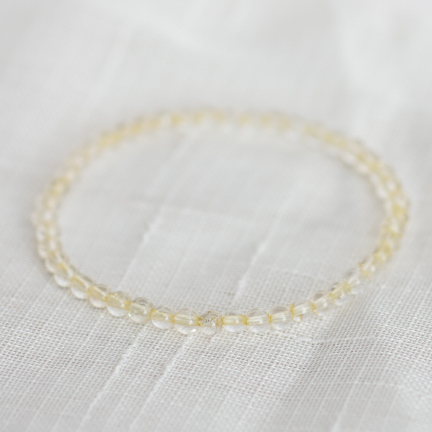 Delicate beaded bracelet on a light fabric background