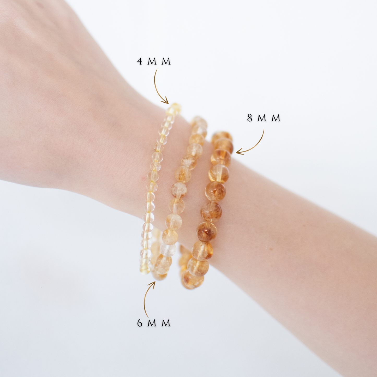 Three beaded bracelets on a wrist with size labels