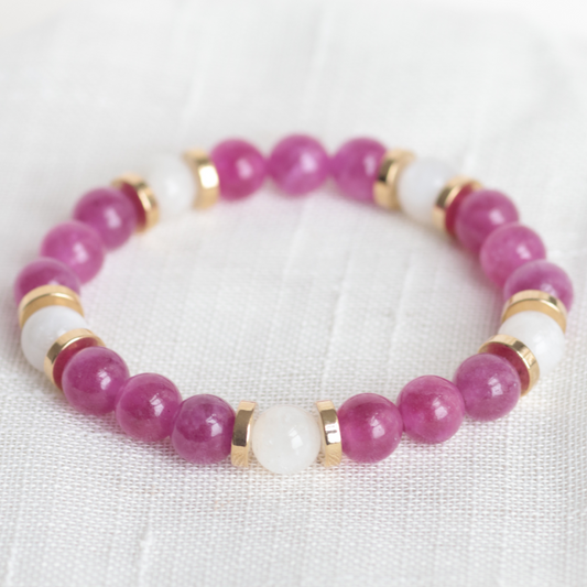 Beaded bracelet with pink and white beads on a light fabric background