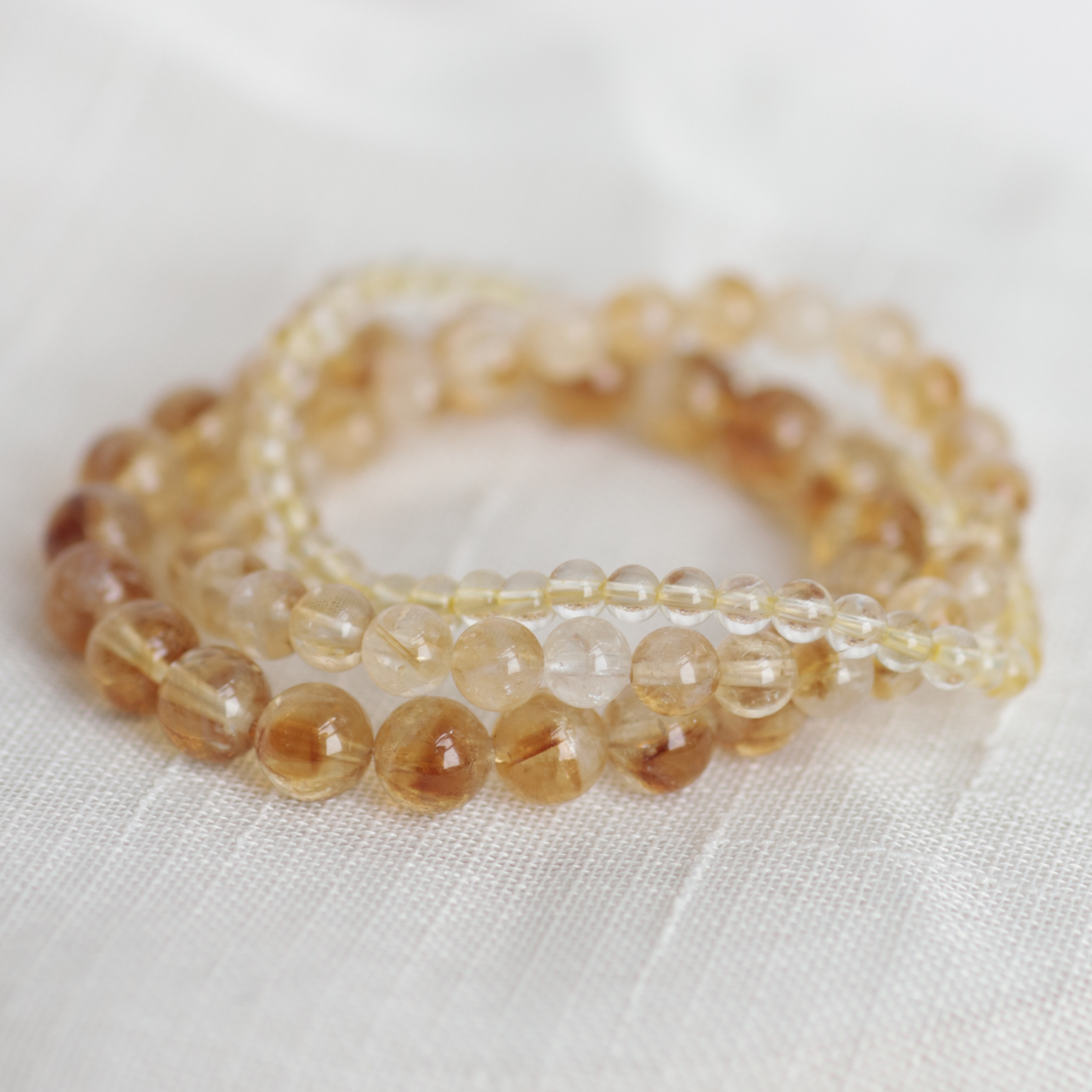 Set of beaded bracelets on a white fabric background