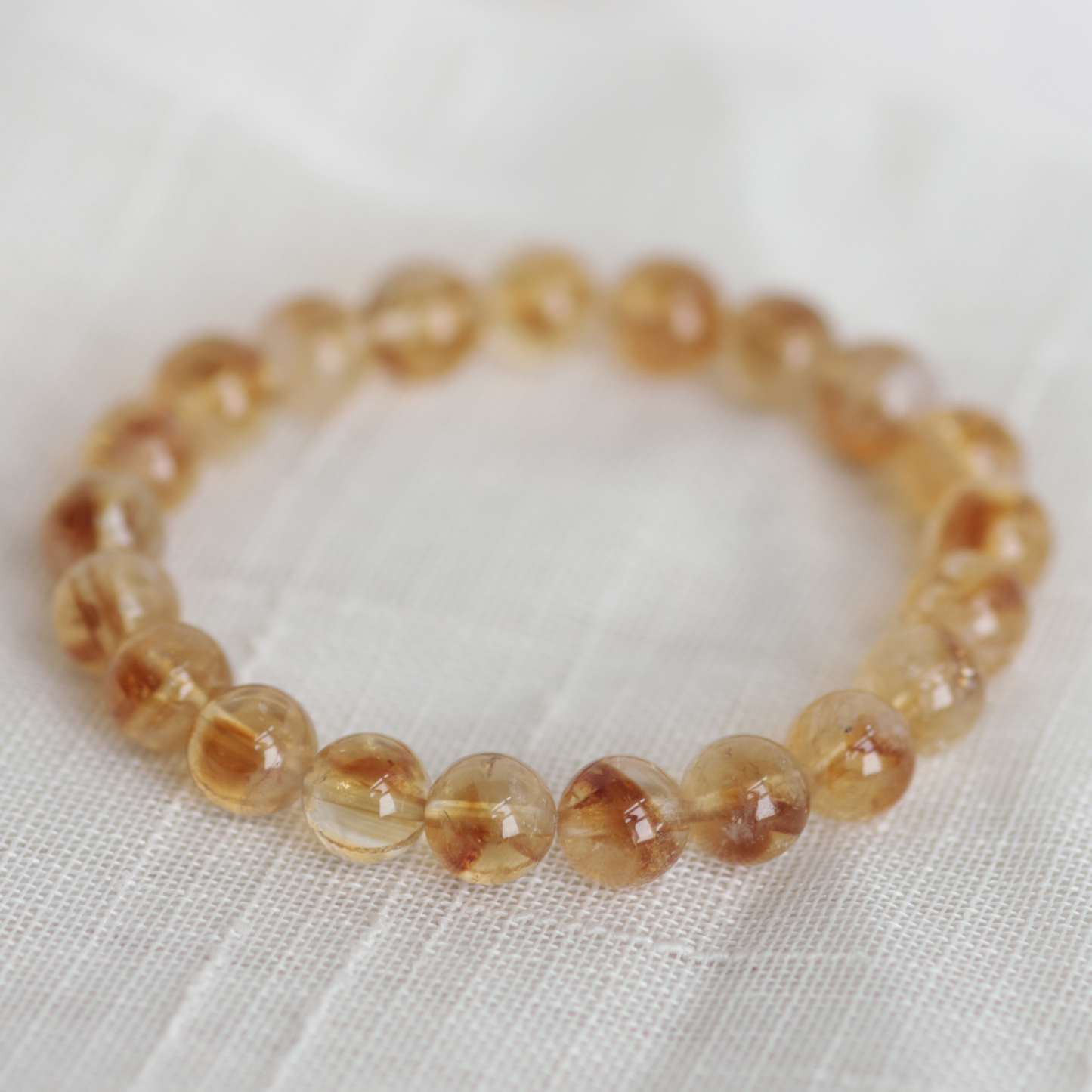 Beaded bracelet with brown and beige stones on a white fabric background